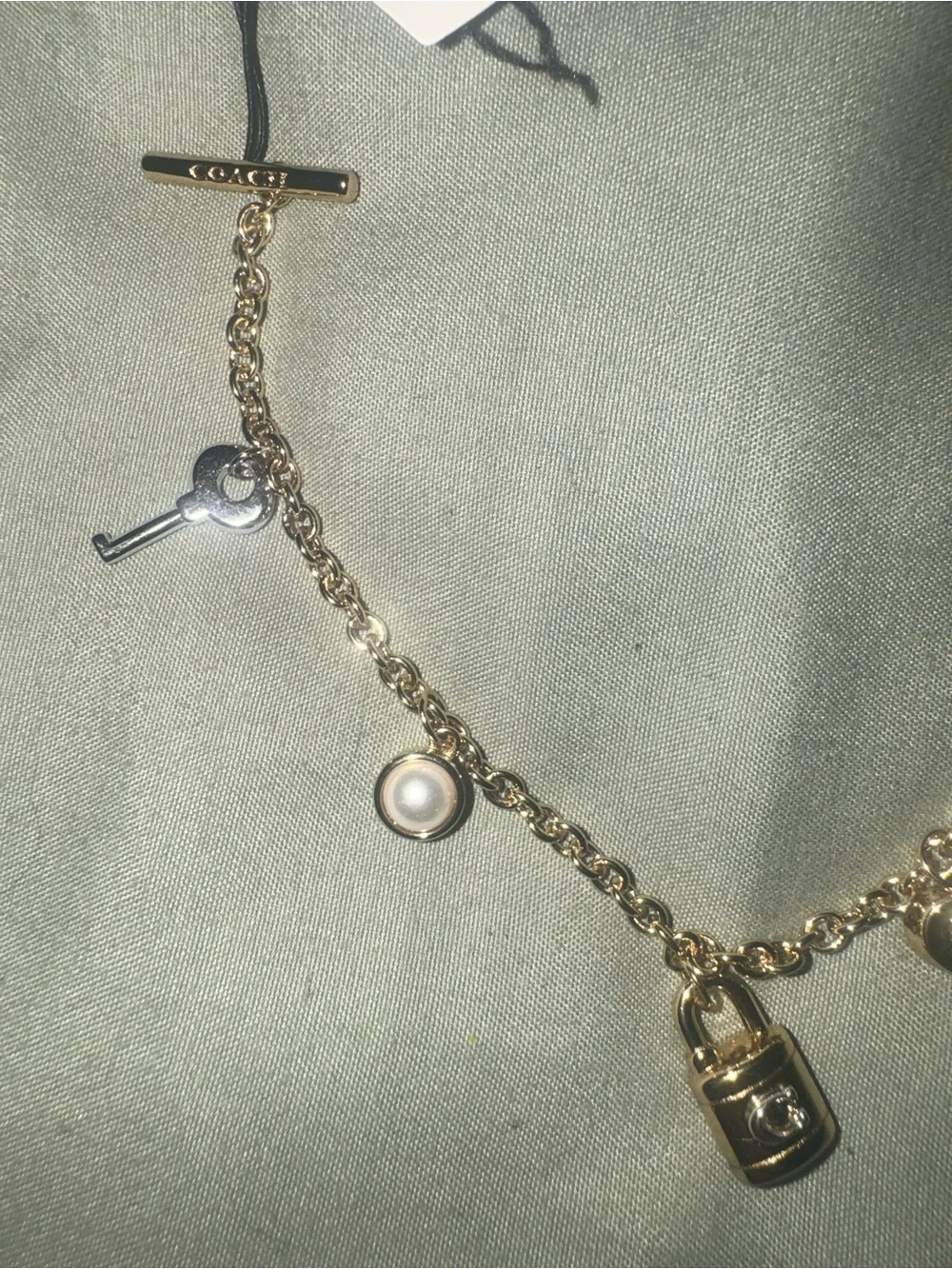 Coach Gold tone Charm Bracelet with Padlock, Key and Pearl Accents CD855 A31